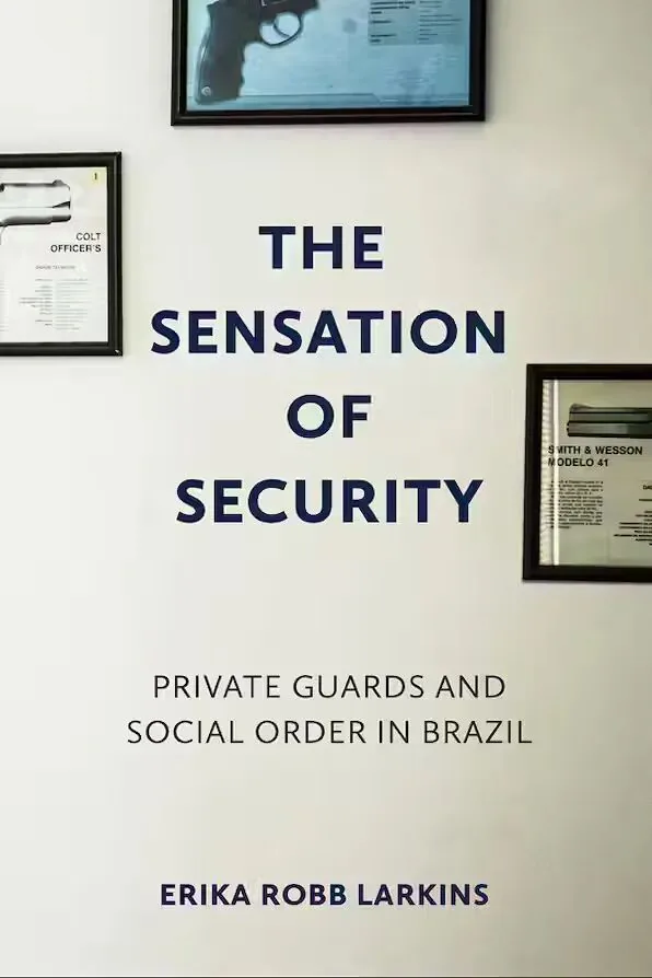 《安全感》（The Sensation of Security）封面，白墙上挂着几幅装裱的手枪展示图片，如柯尔特和史密斯威森型号说明牌。作者艾瑞卡·罗伯·拉金斯。