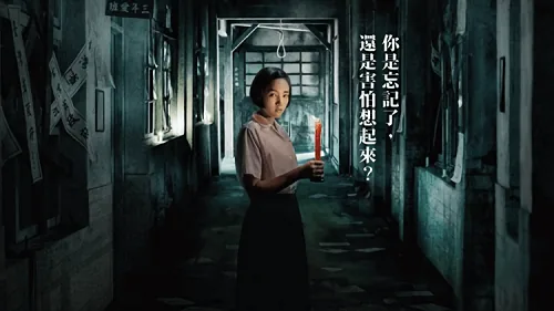 电影海报，一名穿学生制服的女生站在昏暗走廊里手持蜡烛，画面文字为“你是忘记了，还是害怕想起来？”
