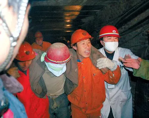 昏暗矿井中,几名戴红色安全帽、穿橙色工作服的矿工正搀扶一名戴口罩的同伴,周围有人伸手协助,气氛紧张。