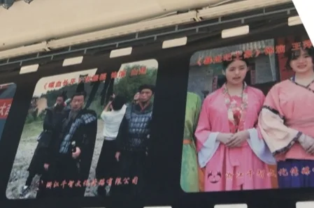 街边宣传栏上并排展示两幅剧照:左图两名男子在户外发生争执,右图两名女子身穿粉色古装站立,图片下方配有说明文字。