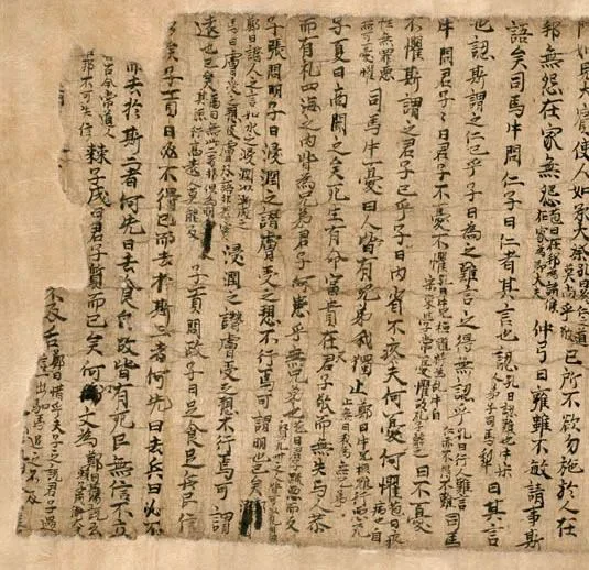 泛黄残破的写本照片,纸面密布竖行毛笔汉字,右侧文字较完整、左侧边缘破损缺字。