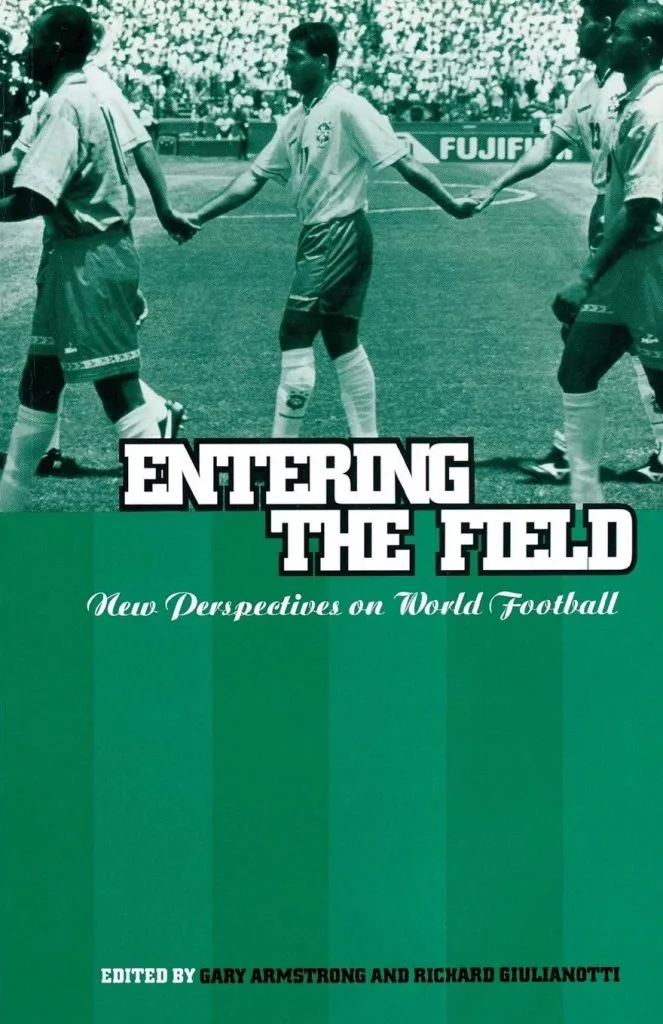 书封《Entering the Field: New Perspectives on World Football》,编者Gary Armstrong和Richard Giulianotti,上部为球员牵手入场的黑白球场照片,下部绿色球场纹底