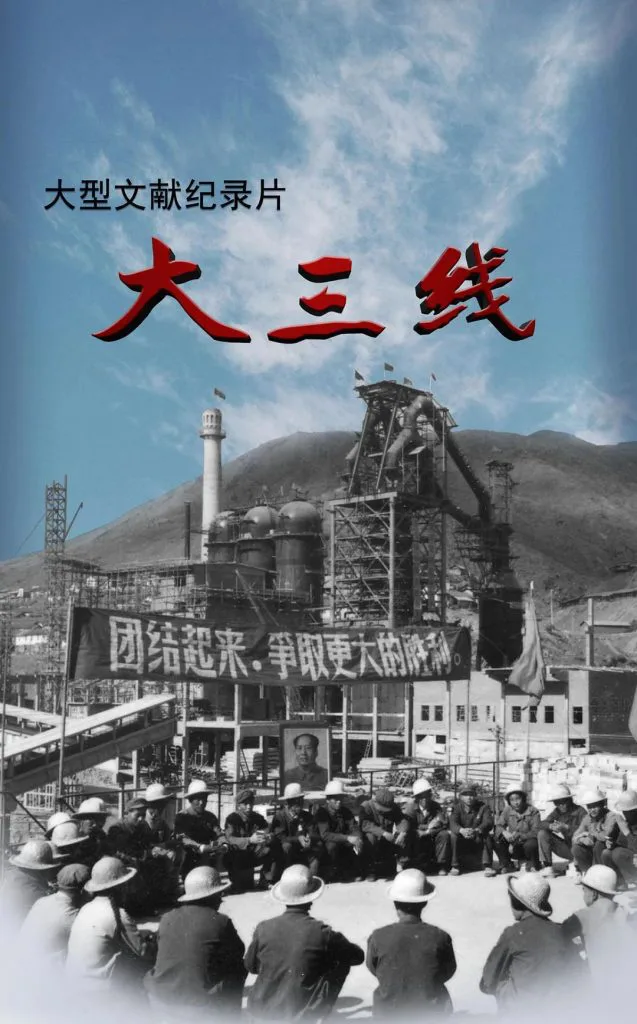 纪录片《大三线》海报,黑白老照片:山间工厂前一群戴安全帽的工人席地而坐,背景悬挂“团结起来,争取更大的胜利”横幅及领袖画像,上方叠加蓝天与红色片名。