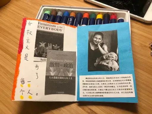 左页手写竖排“女权主义是为了每一个人”,贴着《Feminism is for Everybody》与中译《激情的政治》封面图;右页蓝纸上贴着bell hooks托腮照片及一段印刷文字。