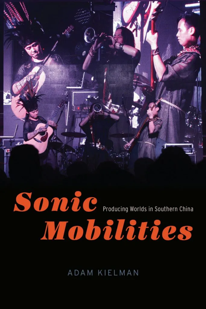 书封《Sonic Mobilities: Producing Worlds in Southern China》（声波流动），作者亚当·乔曼，封面是一支乐队在舞台上演出的照片，一名乐手戴着羽饰头饰。