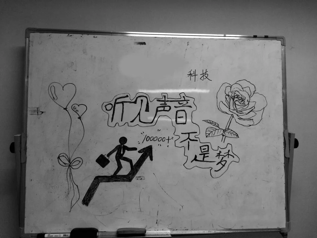黑白照片，白板右上角另写有“科技”二字，上升箭头旁标注“100000+”。