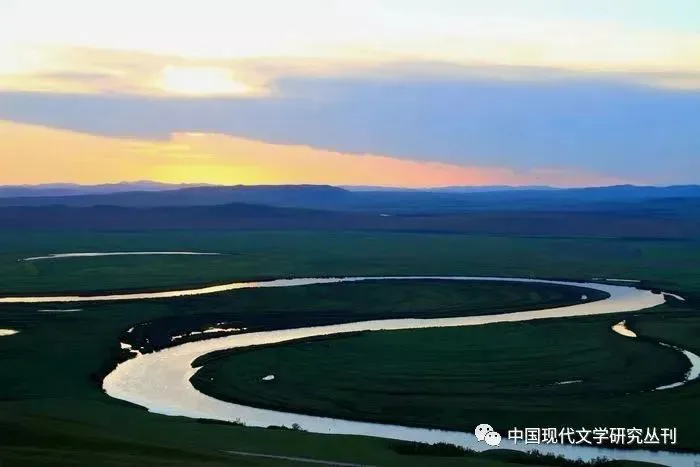 俯瞰视角下,一条河流在绿色苔原上蜿蜒成多个“几”字形弯道,天空是日落时分的橙紫色云霞。