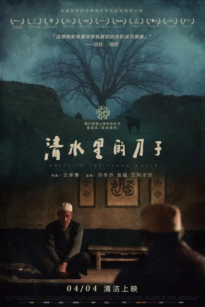 电影《清水里的刀子》海报，上方是枯树剪影和获奖信息，下方两位戴白帽的男子跪坐在土墙庭院中，注明改编自石舒清同名小说