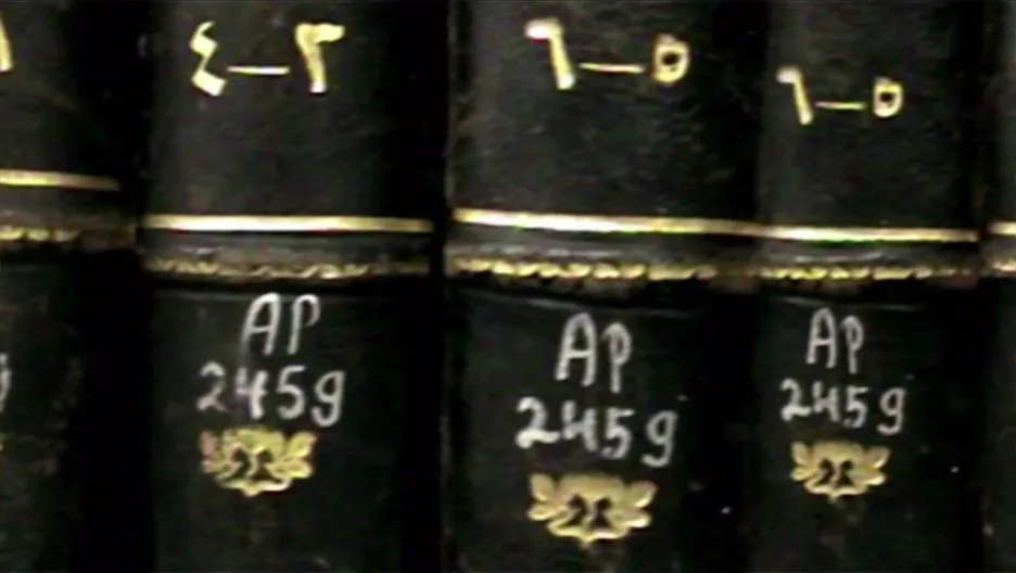 特写：几本深色皮质精装书脊烫金压花，贴着手写标签「AP 245g」，书脊上方另有希伯来字母编号。